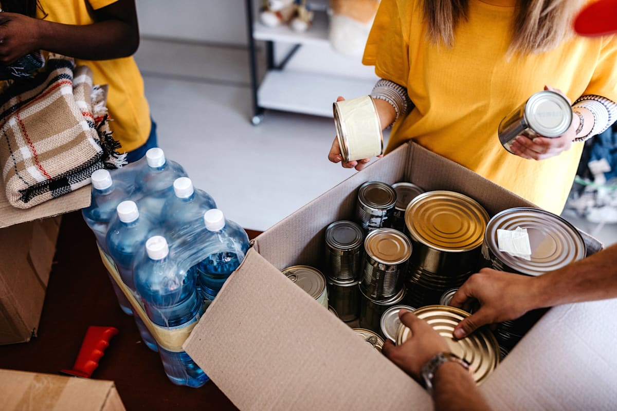 People packing cans and water in a charity centre