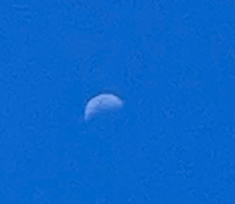 A blurry photo of the moon with blue background