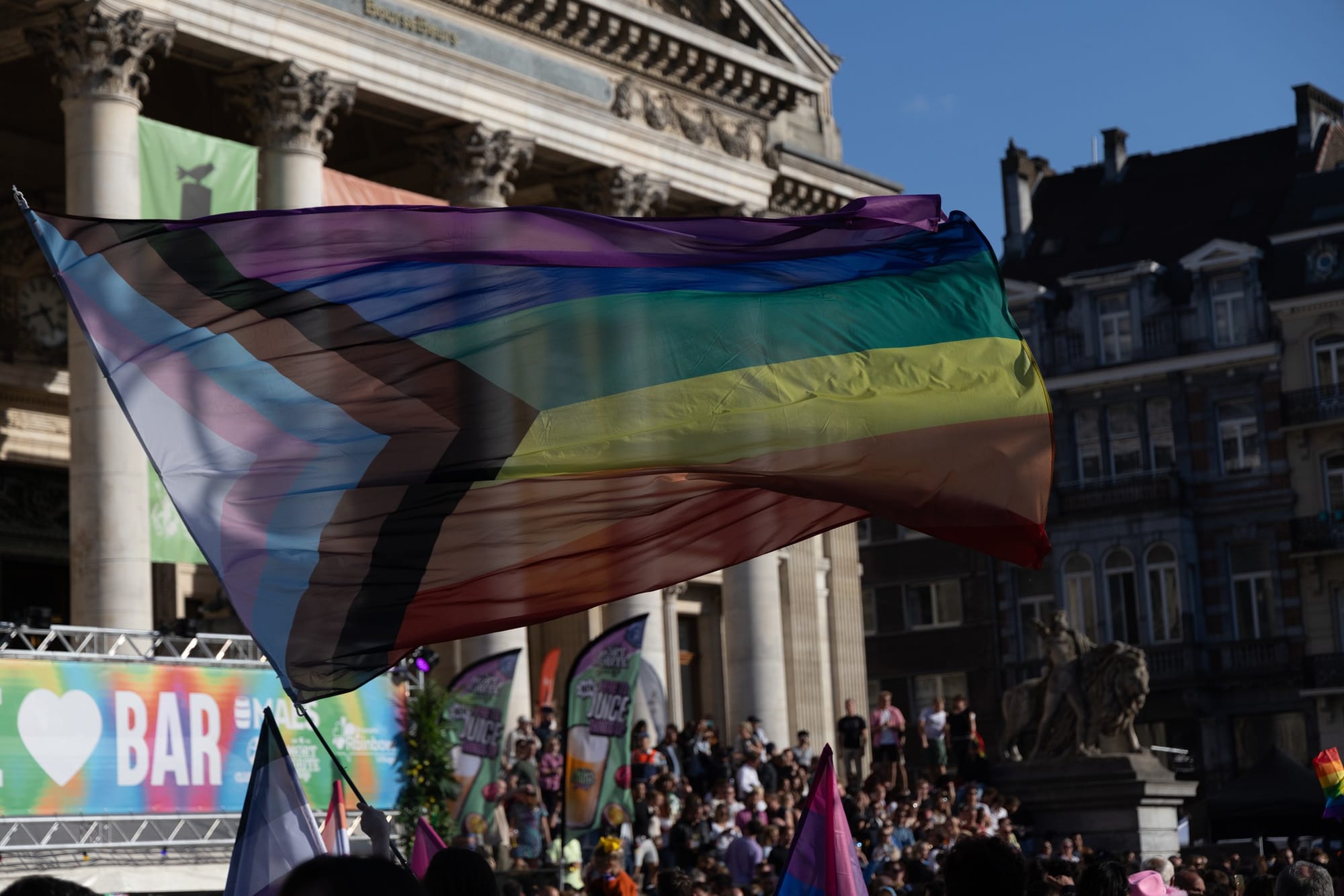 Pride flag waving at outdoor event.