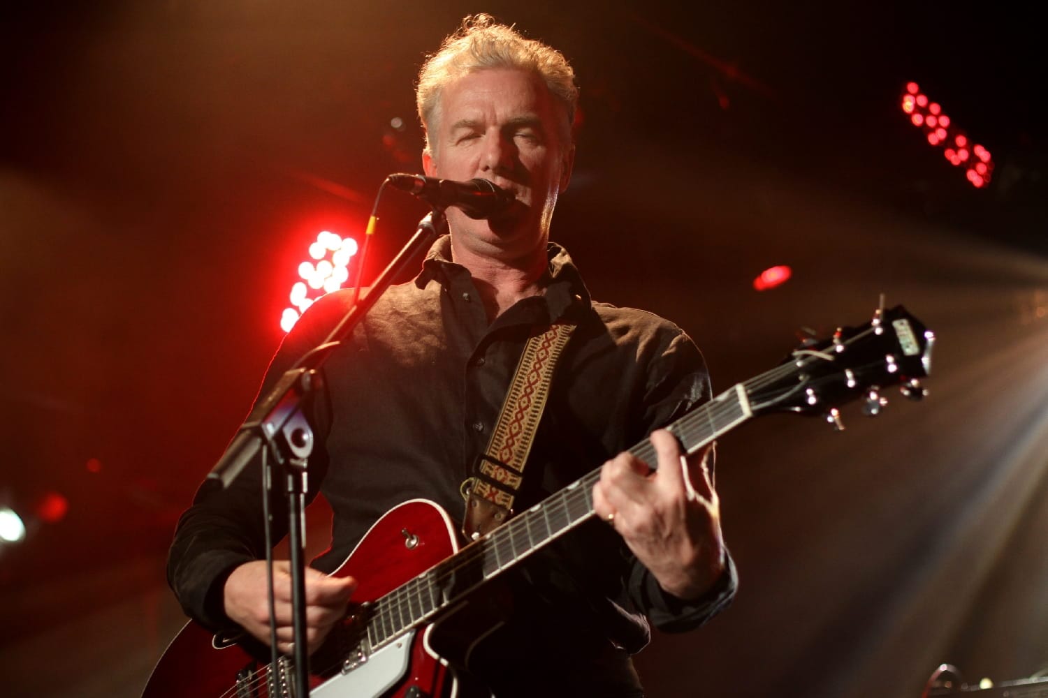 Mick Harvey playing guitar and singing onstage