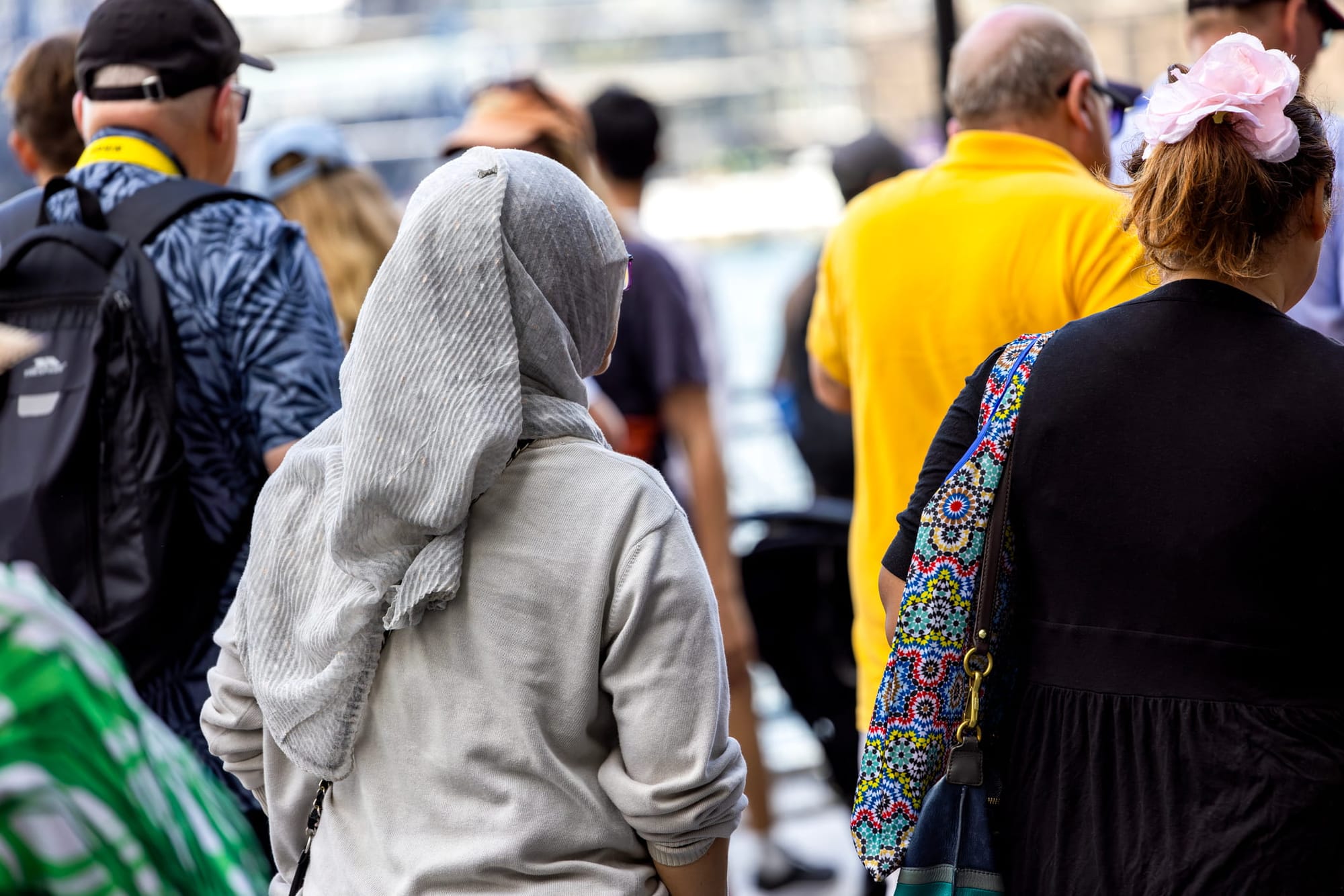 Rear view of woman wearing hijab walking in a crowd of people
