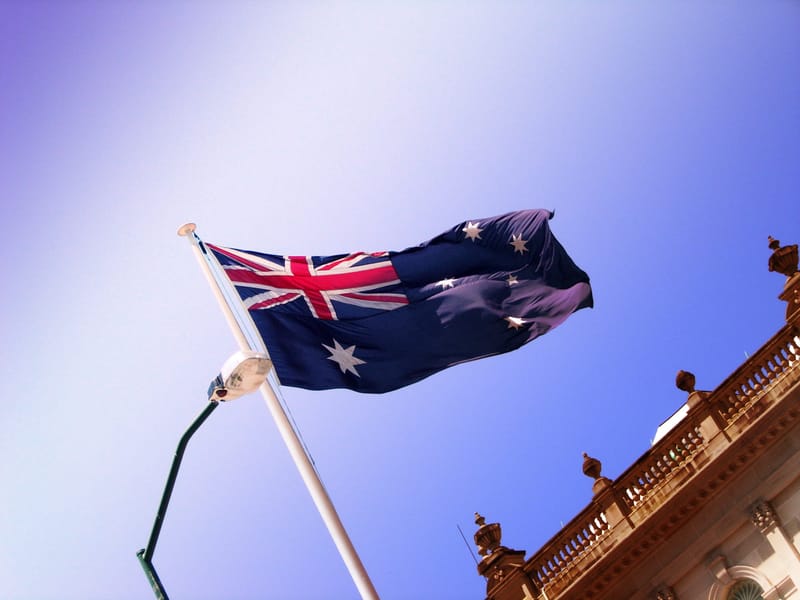 Australian flag flying above a building with blue sky background